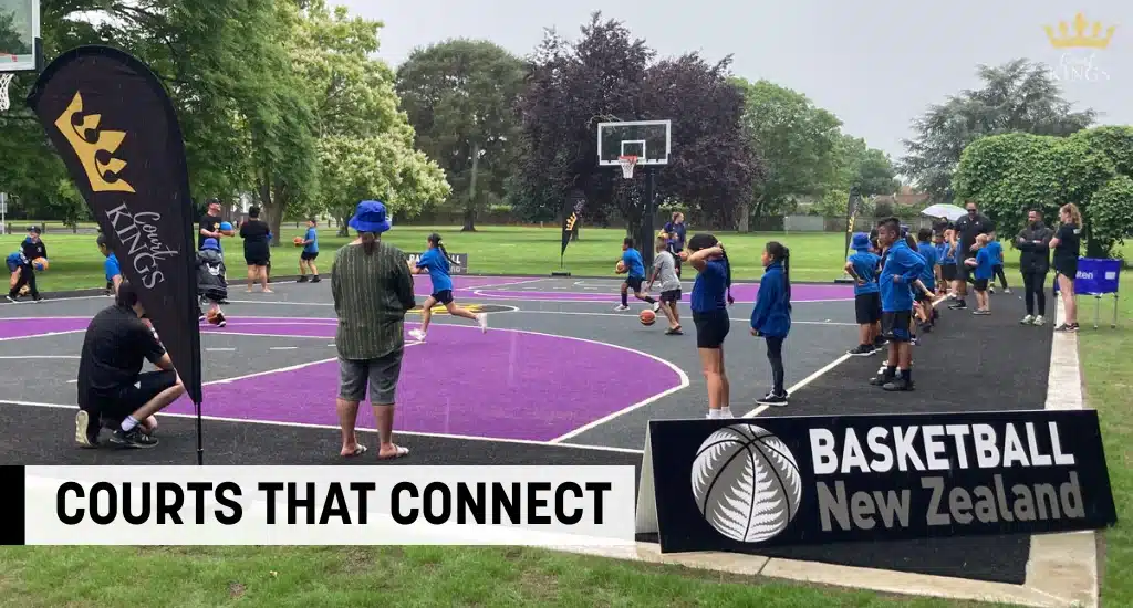 Kids playing basketball on a purple court with Court Kings flag.