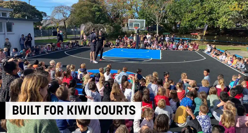 Children gathered on court during a school event with speakers.